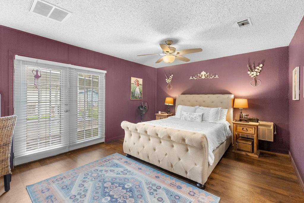1320 Elm Street Bonham, TX 75418 - Photo 16 of 40 a bedroom with a bed chandelier and a window