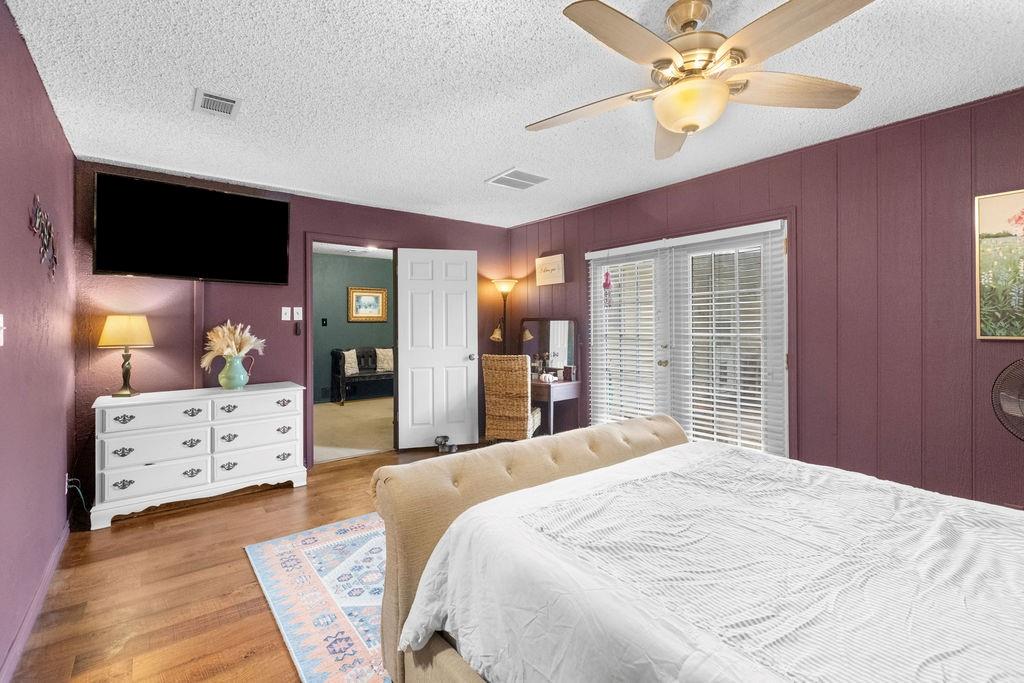 1320 Elm Street Bonham, TX 75418 - Photo 18 of 40 a bedroom with a large bed and a chandelier