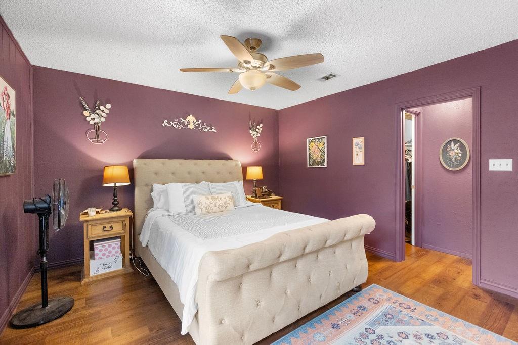 1320 Elm Street Bonham, TX 75418 - Photo 19 of 40 a bedroom with a bed and a chandelier