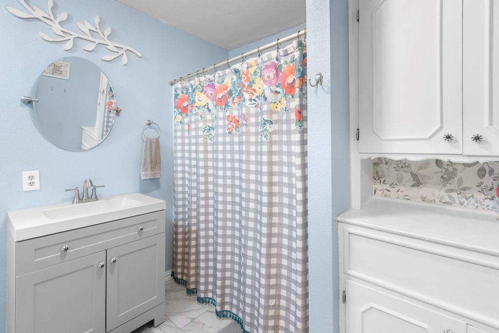 1320 Elm Street Bonham, TX 75418 - Photo 20 of 40 a bathroom with a sink a vanity and a mirror