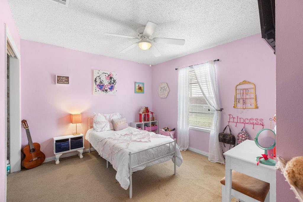 1320 Elm Street Bonham, TX 75418 - Photo 24 of 40 a bedroom with a bed and a chandelier