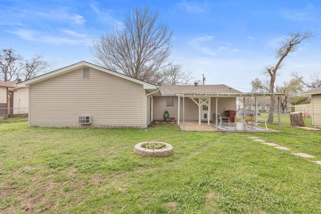 1320 Elm Street Bonham, TX 75418 - Photo 32 of 40 a view of a white house with a yard table and chairs