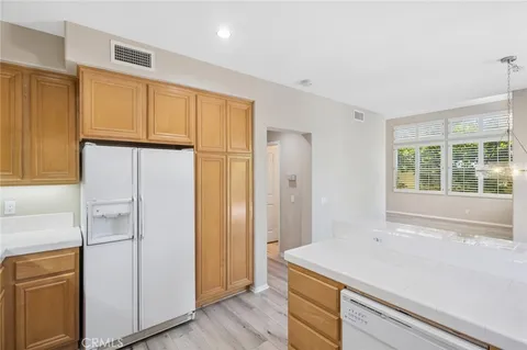 a kitchen with a refrigerator and countertop cabinets