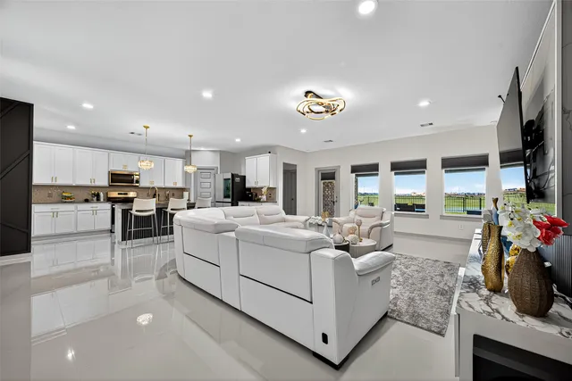 a living room with furniture a table and kitchen view