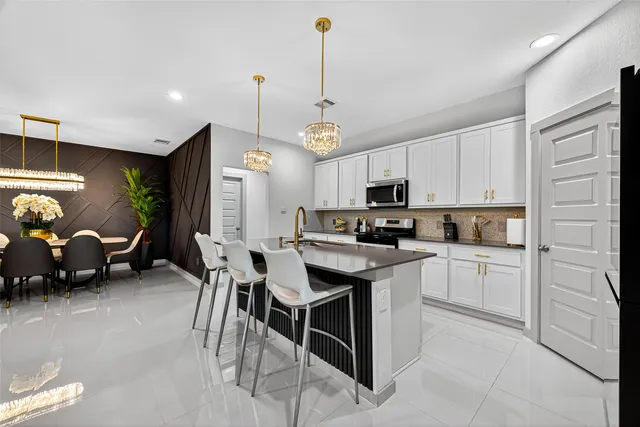 a kitchen with kitchen island granite countertop a sink a center island and cabinets