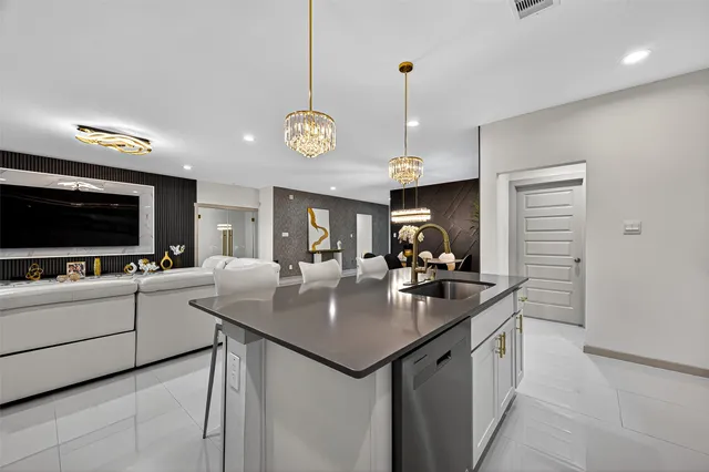 a kitchen with stainless steel appliances kitchen island granite countertop a refrigerator a stove a microwave oven a sink with a dining table and chairs