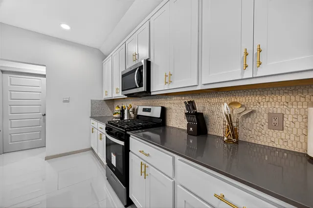 a kitchen with stainless steel appliances granite countertop a sink a stove and a wooden floors