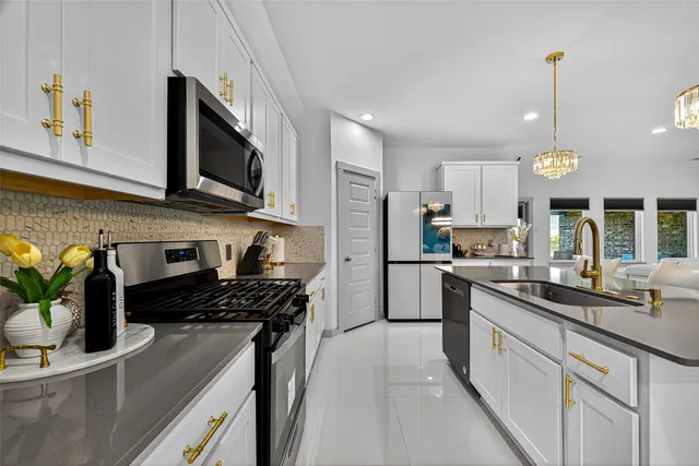 a kitchen with stainless steel appliances granite countertop white cabinets and a stove