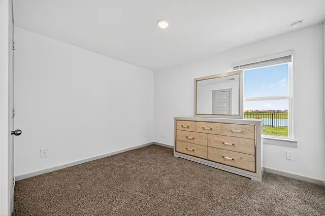 a bedroom with a bed and a flat tv screen on wall