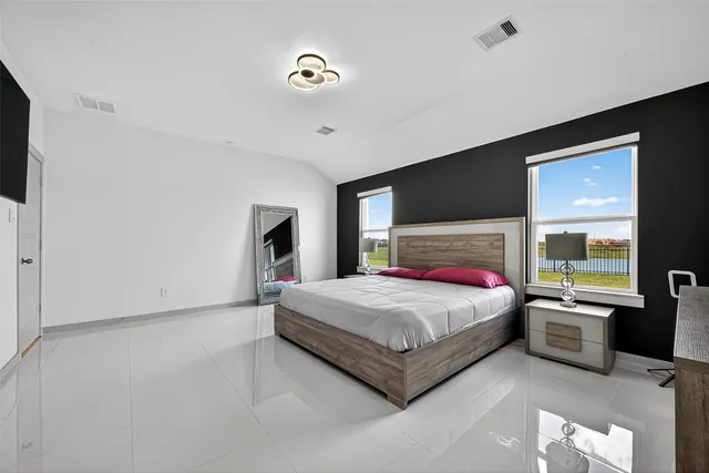 a bedroom with a bed and a flat screen tv