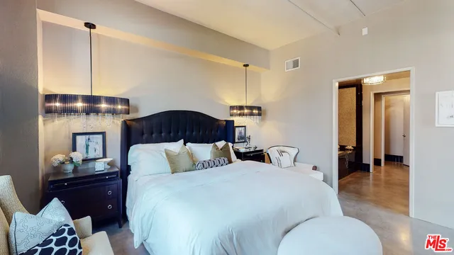 a bedroom with a bed and dresser with mirror