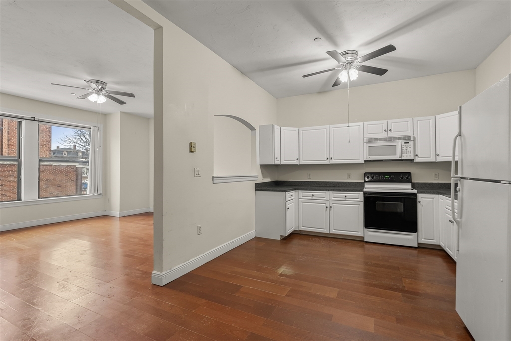 7 Main Street, Unit 102 Brockton, MA 02301 - Photo 16 of 31 a kitchen with granite countertop white cabinets and stainless steel appliances