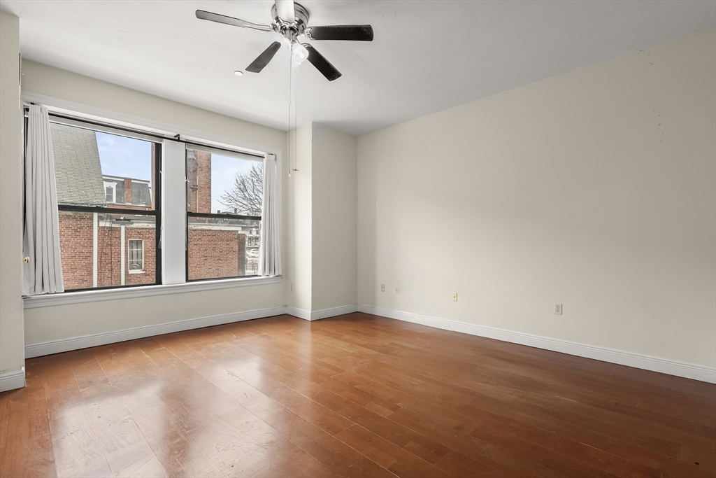 7 Main Street, Unit 102 Brockton, MA 02301 - Photo 17 of 31 an empty room with wooden floor fan and windows