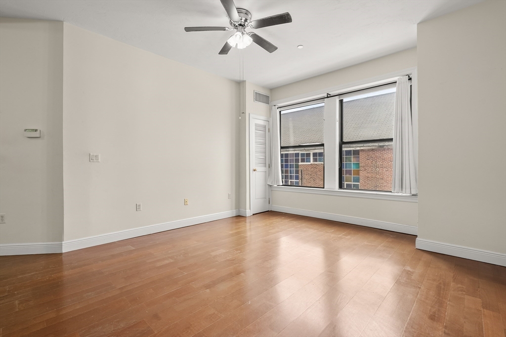7 Main Street, Unit 102 Brockton, MA 02301 - Photo 18 of 31 a view of an empty room with a window and wooden floor