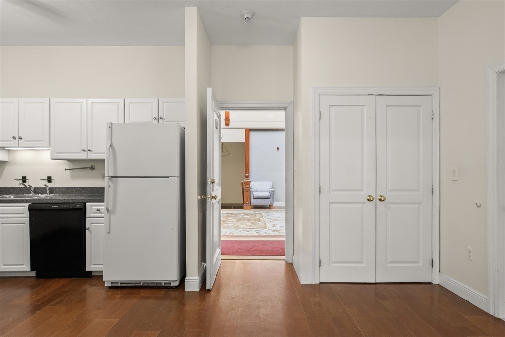 7 Main Street, Unit 102 Brockton, MA 02301 - Photo 25 of 31 a view of a kitchen with a refrigerator a stove top oven and cabinets