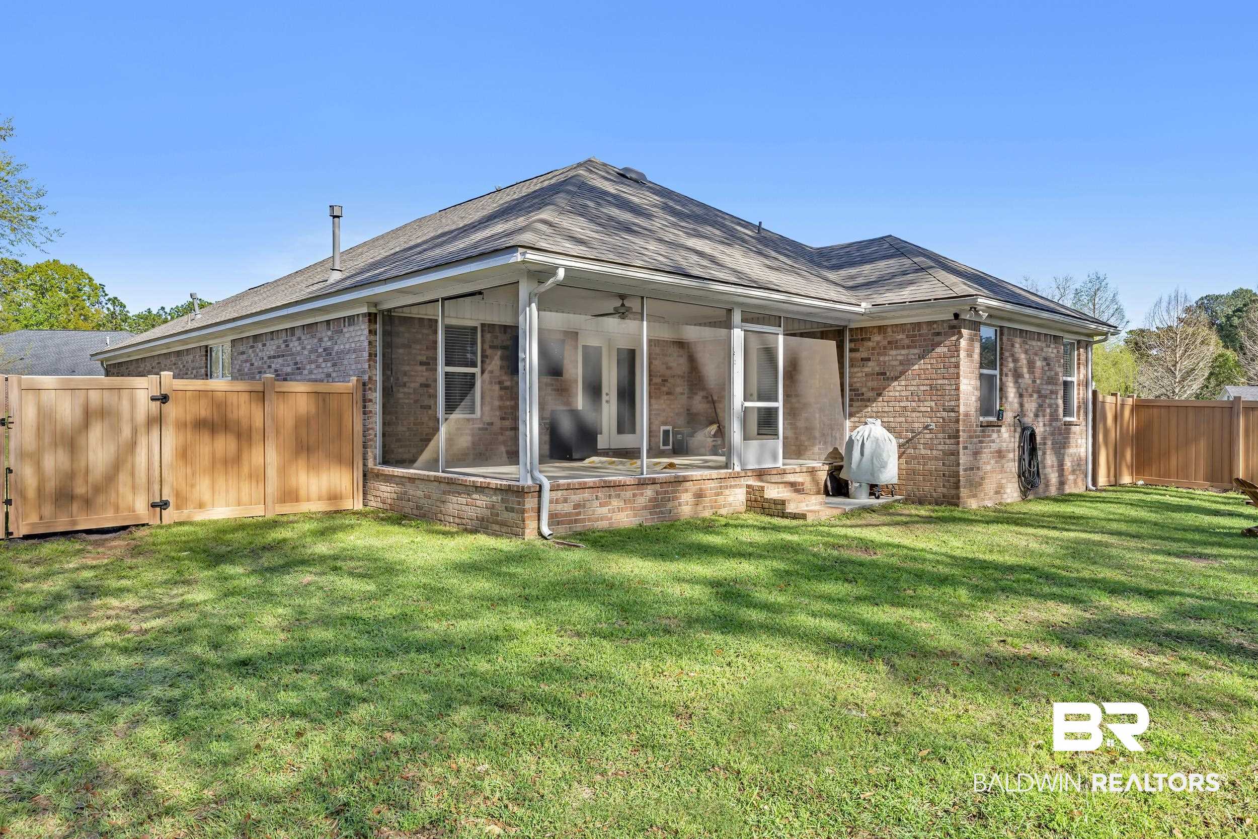 31527 Heidelbrook Loop Daphne, AL 36527 - Photo 21 of 22 Back of property featuring a sunroom, a gate, a fenced backyard, brick siding, and ceiling fan