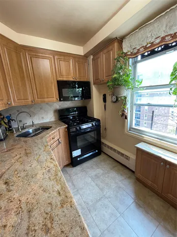 a kitchen with granite countertop a stove a sink and a microwave