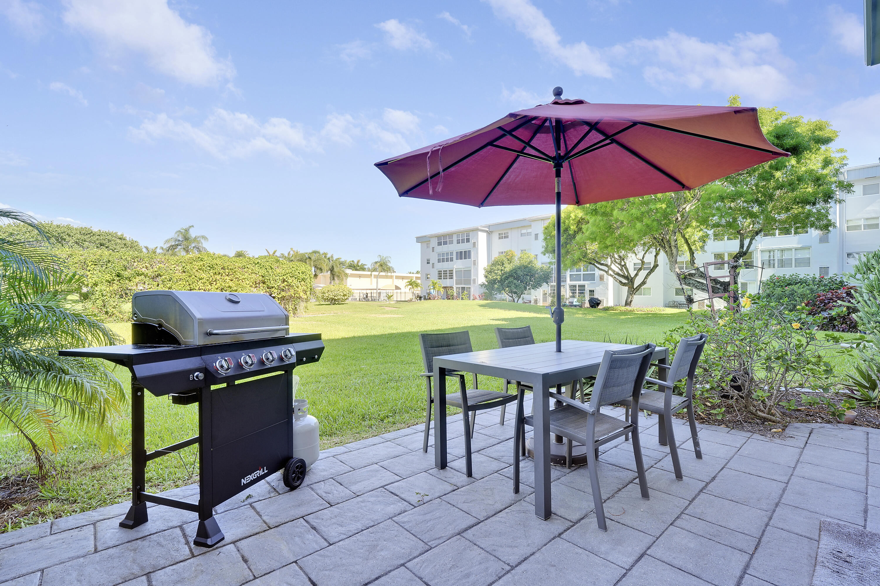 2400 Northeast 1st Lane, Unit 1020 Boynton Beach, FL 33435 - Photo 18 of 34 an outdoor space with furniture and umbrella