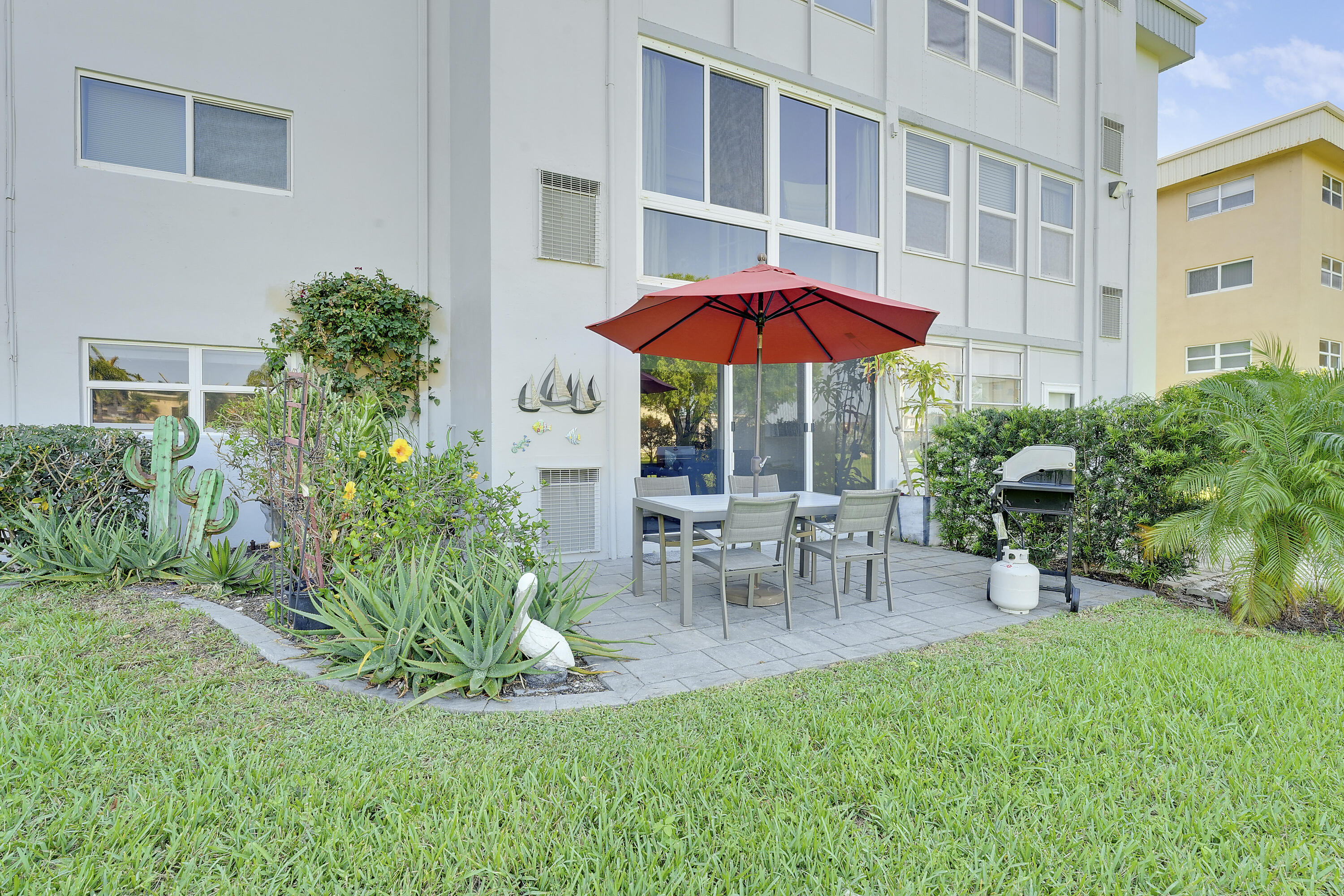 2400 Northeast 1st Lane, Unit 1020 Boynton Beach, FL 33435 - Photo 19 of 34 a view of a house with backyard sitting area and garden