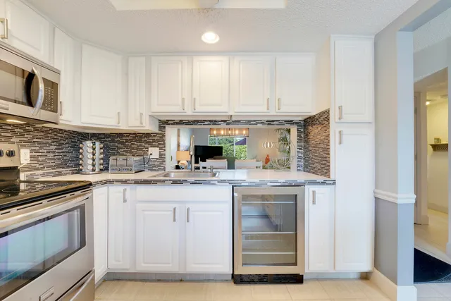 a kitchen with stainless steel appliances granite countertop a stove and white cabinets