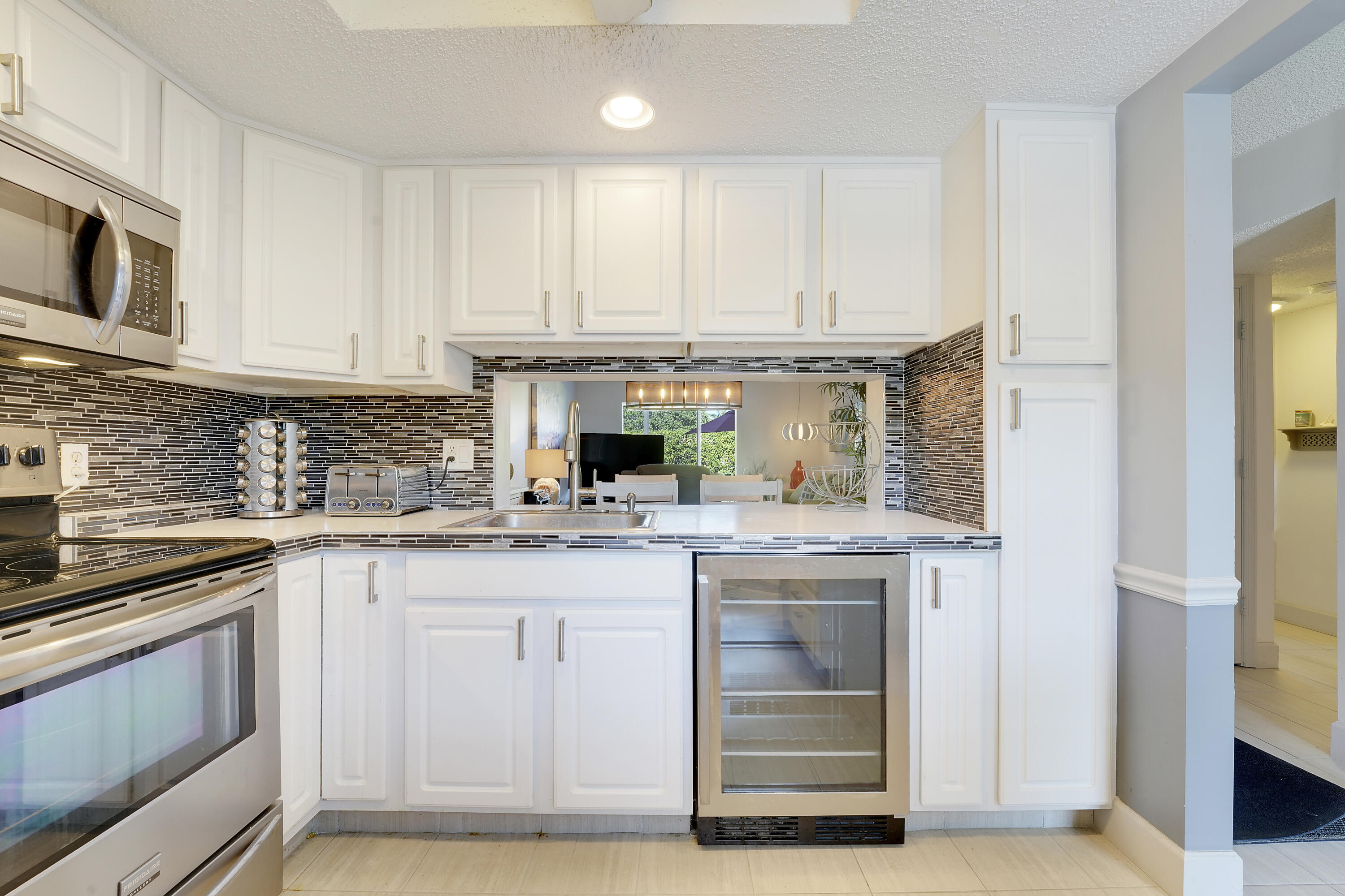 2400 Northeast 1st Lane, Unit 1020 Boynton Beach, FL 33435 - Photo 5 of 34 a kitchen with stainless steel appliances granite countertop a stove and white cabinets