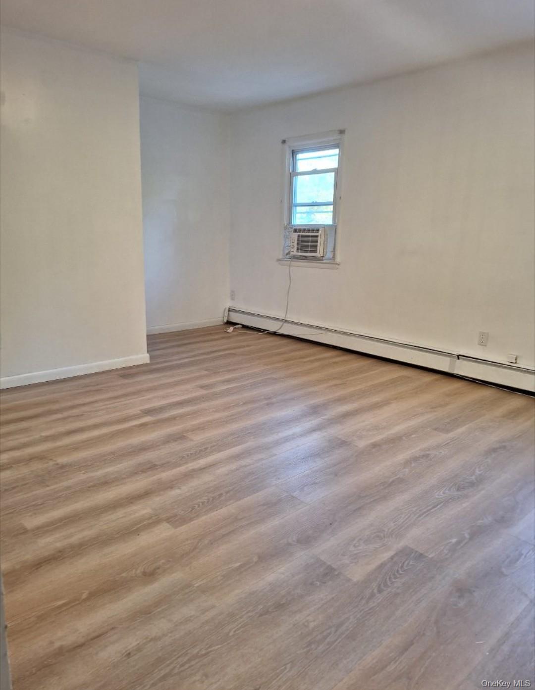 652 Highway 211, Unit 1 Middletown, NY 10940 - Photo 13 of 18 an empty room with wooden floor and windows