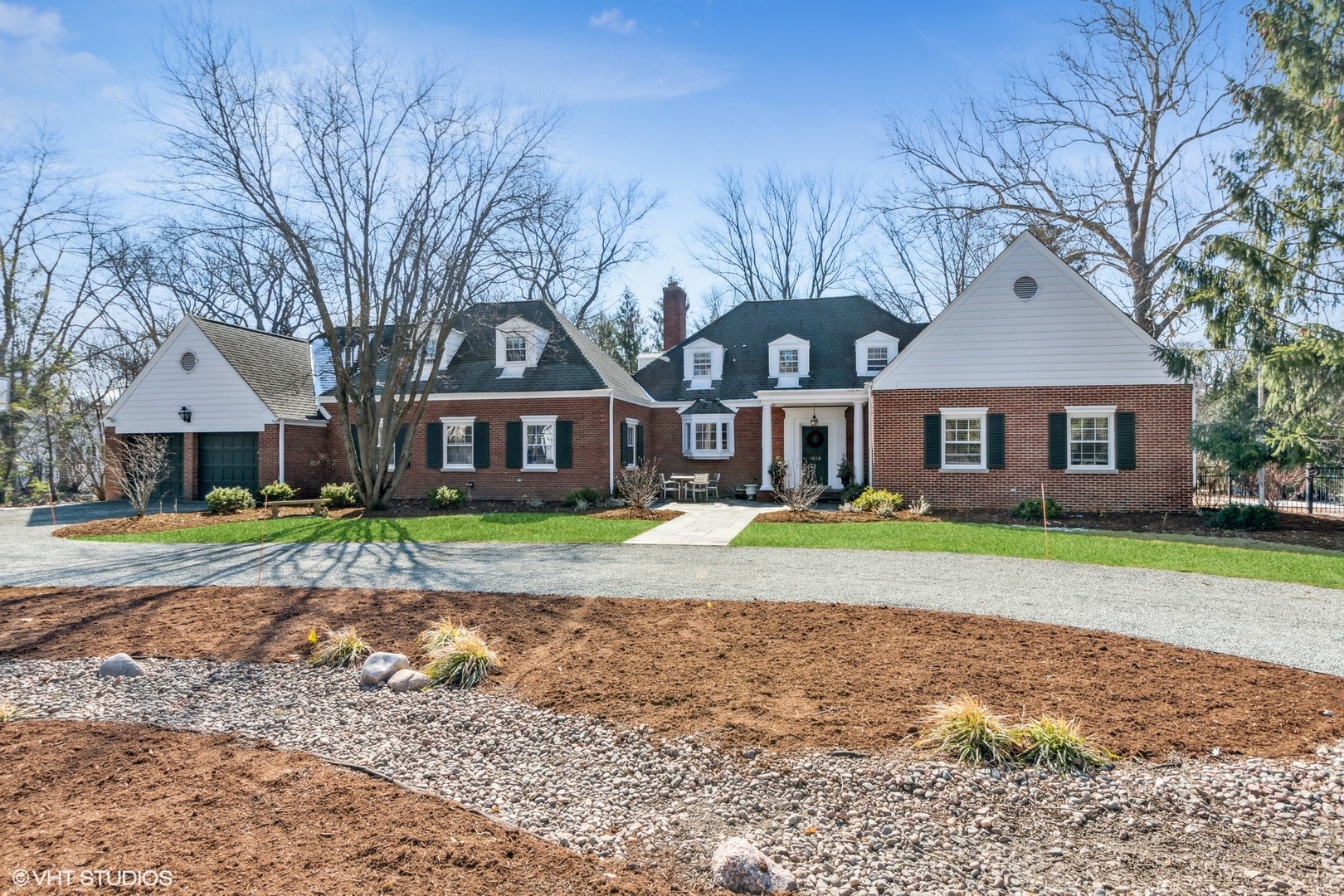 a front view of a house with a garden and trees