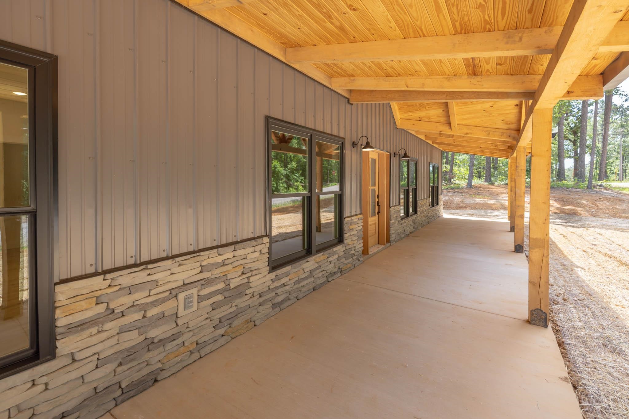 37 William Teague Lane Ramer, TN 38367 - Photo 9 of 39 Spacious covered porch with a natural wood plank ceiling and exposed wood beams