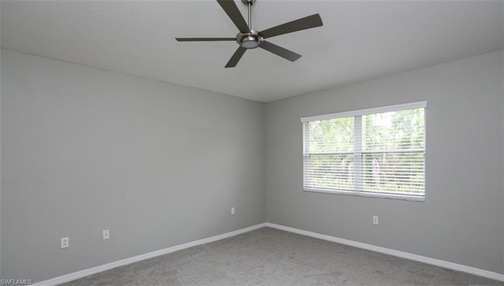 6645 Huntington Lakes Circle, Unit 201 Naples, FL 34119 - Photo 18 of 48 Carpeted empty room with ceiling fan