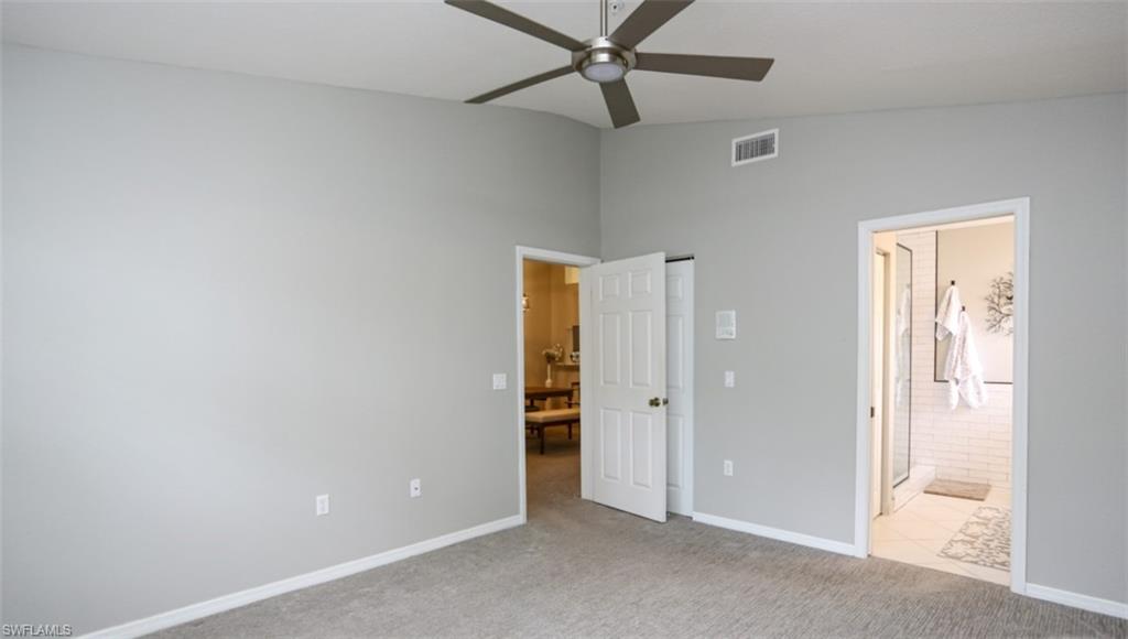 6645 Huntington Lakes Circle, Unit 201 Naples, FL 34119 - Photo 19 of 48 Unfurnished bedroom featuring connected bathroom, light colored carpet, ceiling fan, and lofted ceiling