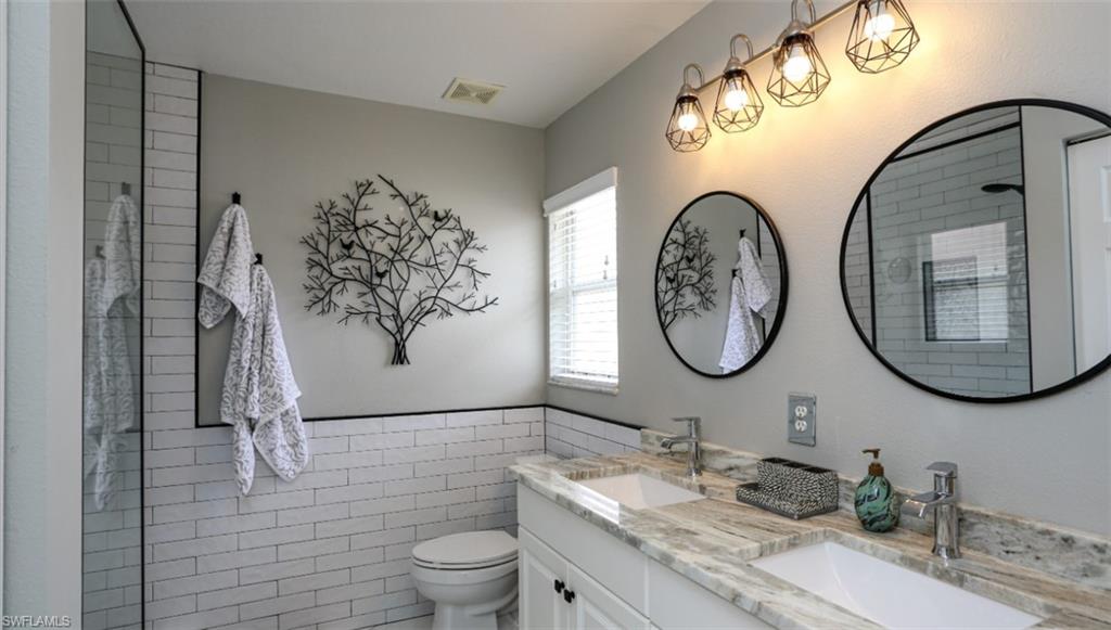 6645 Huntington Lakes Circle, Unit 201 Naples, FL 34119 - Photo 20 of 48 Bathroom with vanity, tile walls, and toilet