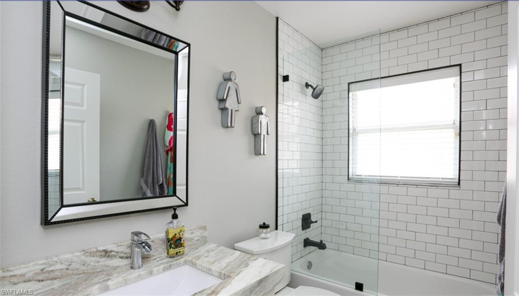 6645 Huntington Lakes Circle, Unit 201 Naples, FL 34119 - Photo 21 of 48 Full bathroom with toilet, vanity, and tiled shower / bath