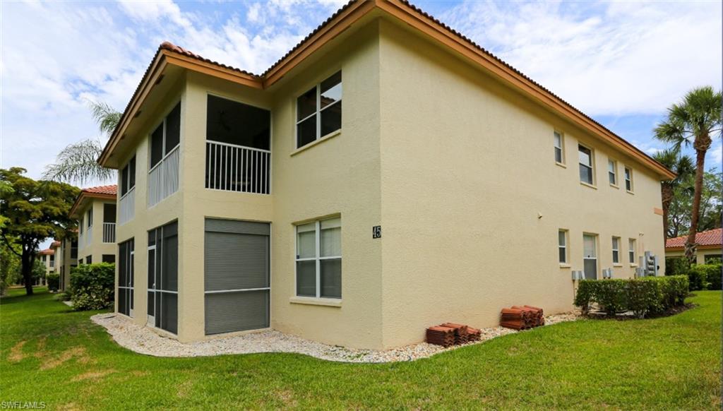 6645 Huntington Lakes Circle, Unit 201 Naples, FL 34119 - Photo 47 of 48 Rear view of property featuring a yard