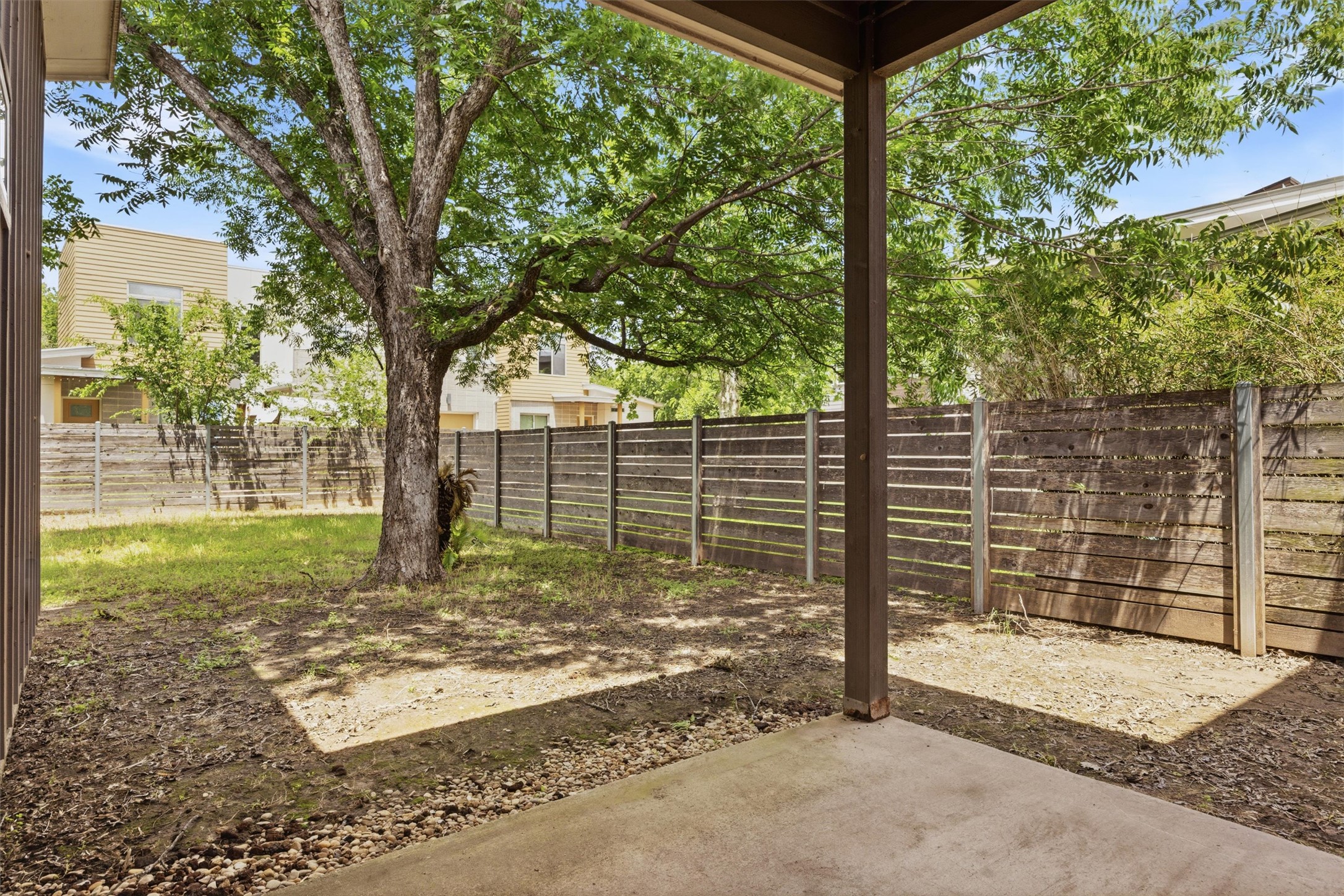 1210 Stobaugh Street, Unit B Austin, TX 78757 - Photo 5 of 40 A spacious backyard with mature shade trees, offering ample room for outdoor activities and relaxation.