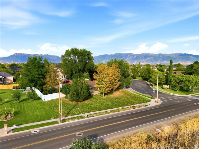 2455 South Bluff Road Syracuse, UT 84075 - Photo 5 of 32 Scenic corner lot with mature landscaping, manicured lawn, and established trees