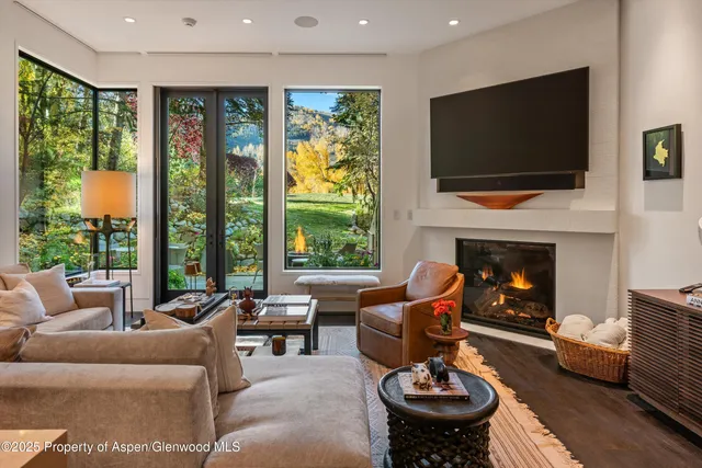 a living room with furniture a flat screen tv and a fireplace