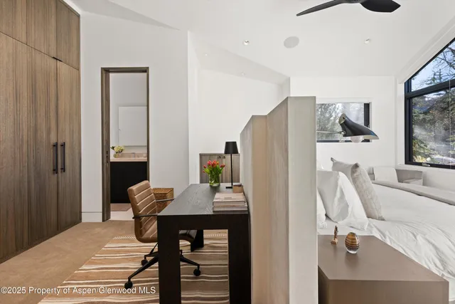 a bedroom with furniture and a large window