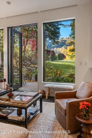 a living room with furniture fireplace and large window
