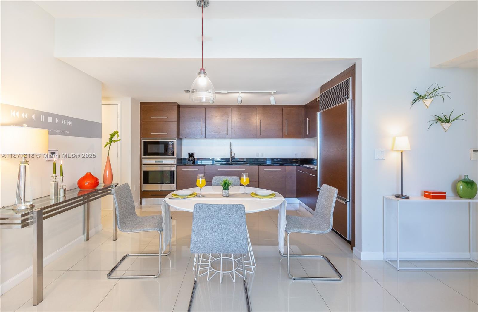 485 Brickell Avenue, Unit 4101 Miami, FL 33131 - Photo 13 of 14 a open kitchen with stainless steel appliances kitchen island granite countertop a table chairs and a refrigerator