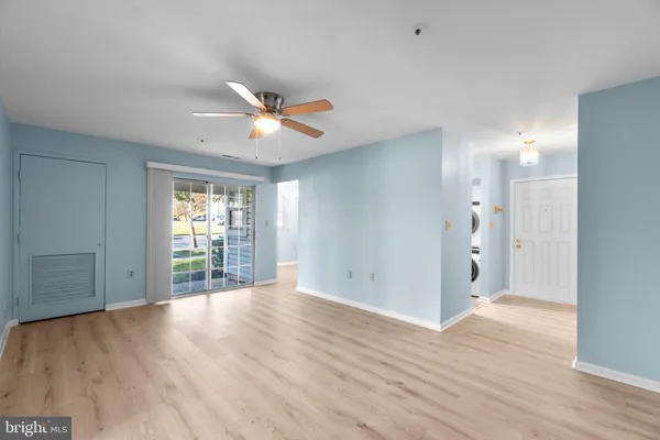 a view of a big room with wooden floor and a ceiling fan