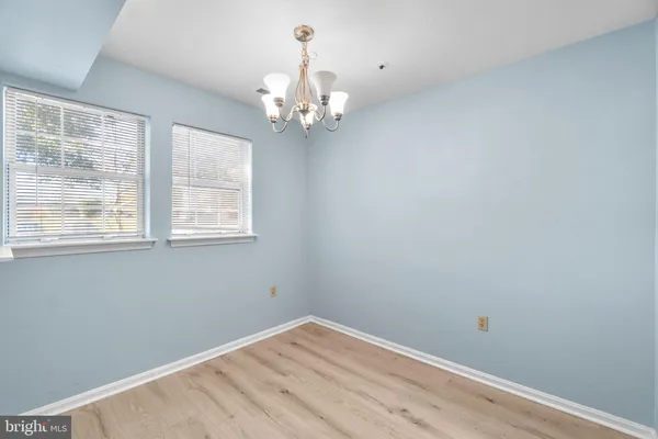 a view of a hallway with wooden floor and a chandelier