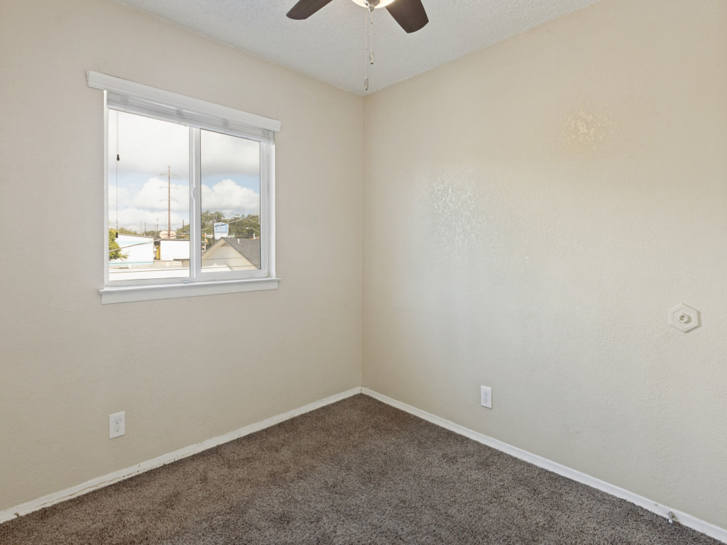 2401 Manor Road, Unit 218 Austin, TX 78722 - Photo 24 of 27 A well-lit bedroom features plush carpeting and a bright window with neighborhood views.