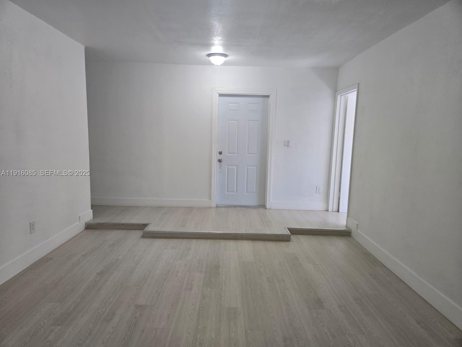 637 West 31st Street Hialeah, FL 33012 - Photo 11 of 20 an empty room with wooden floor and windows