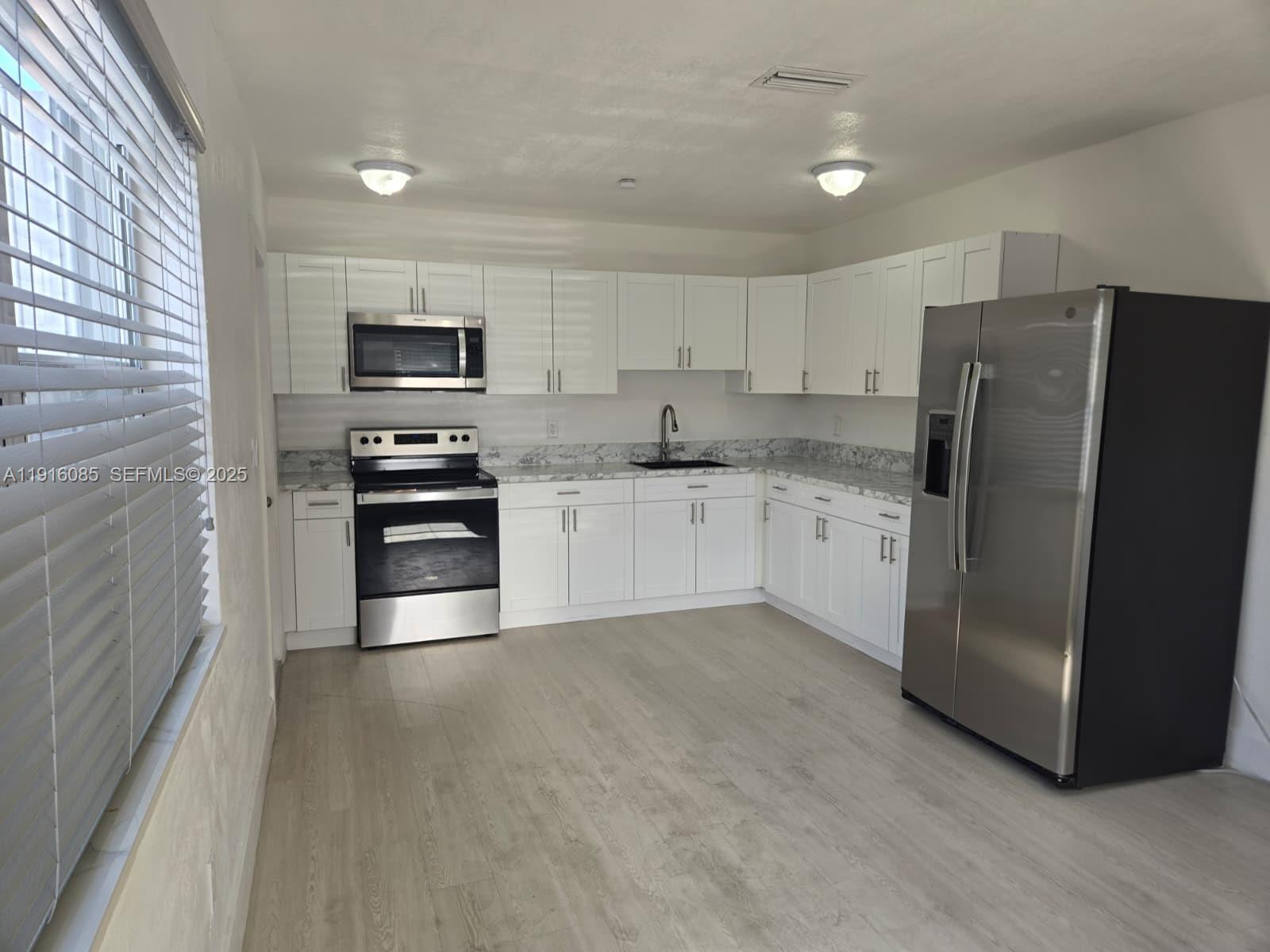 637 West 31st Street Hialeah, FL 33012 - Photo 4 of 20 a kitchen with stainless steel appliances a refrigerator sink and microwave