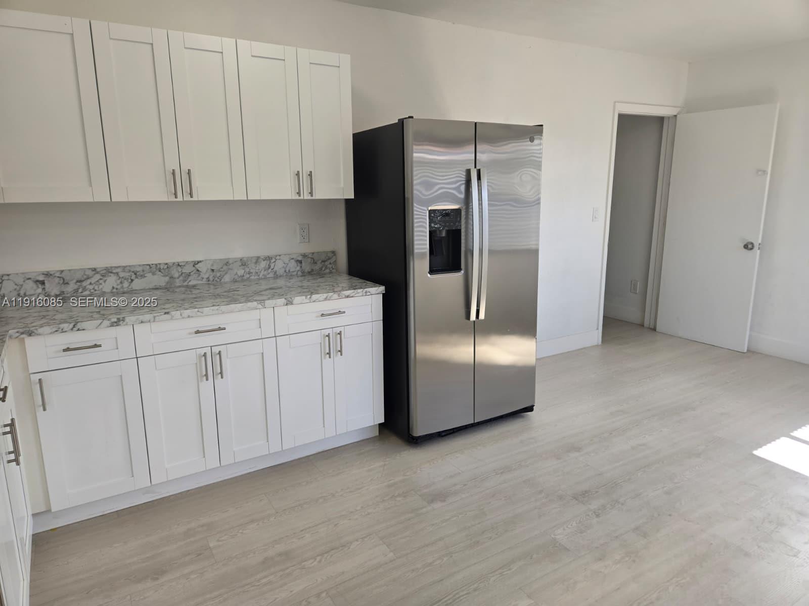637 West 31st Street Hialeah, FL 33012 - Photo 5 of 20 a kitchen with stainless steel appliances granite countertop a refrigerator a stove and white cabinets