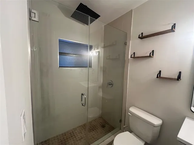 a bathroom with a toilet and a shower