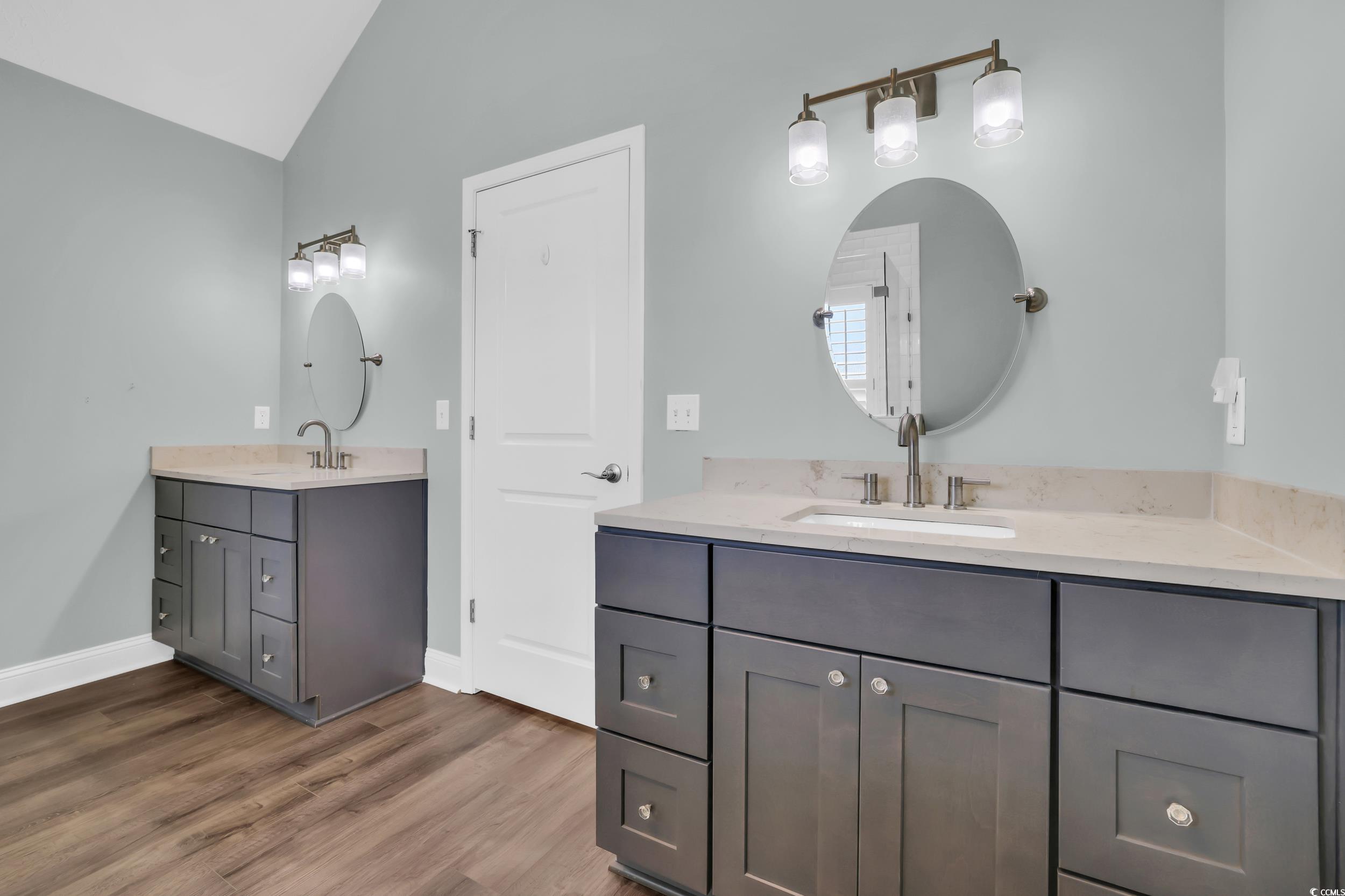 442 Deer Watch Circle Longs, SC 29568 - Photo 20 of 40 Full bathroom with two vanities, vaulted ceiling, and dark wood finished floors