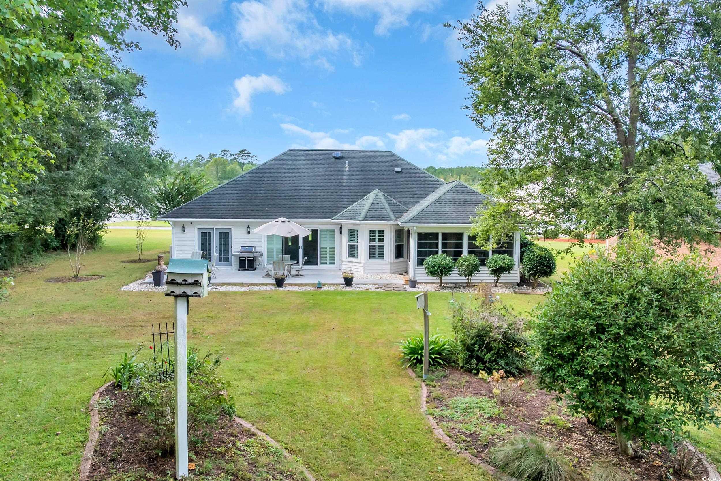 442 Deer Watch Circle Longs, SC 29568 - Photo 27 of 40 Rear view of house with roof with shingles, a patio, french doors, and a lawn