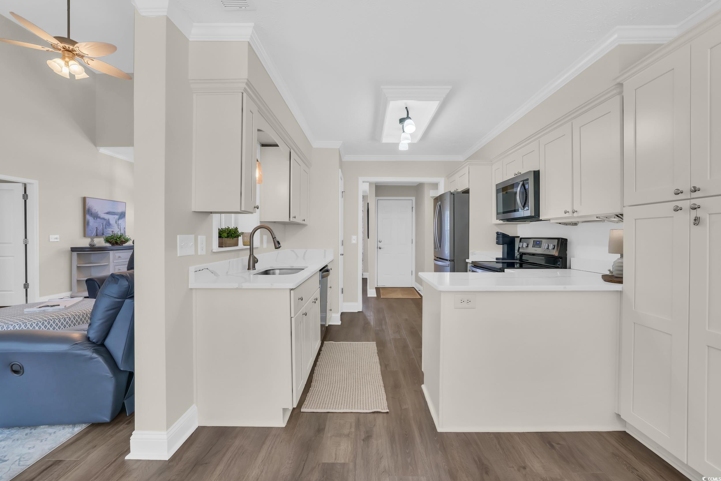 442 Deer Watch Circle Longs, SC 29568 - Photo 3 of 40 Kitchen with white cabinets, a peninsula, dark wood-style flooring, and ornamental molding