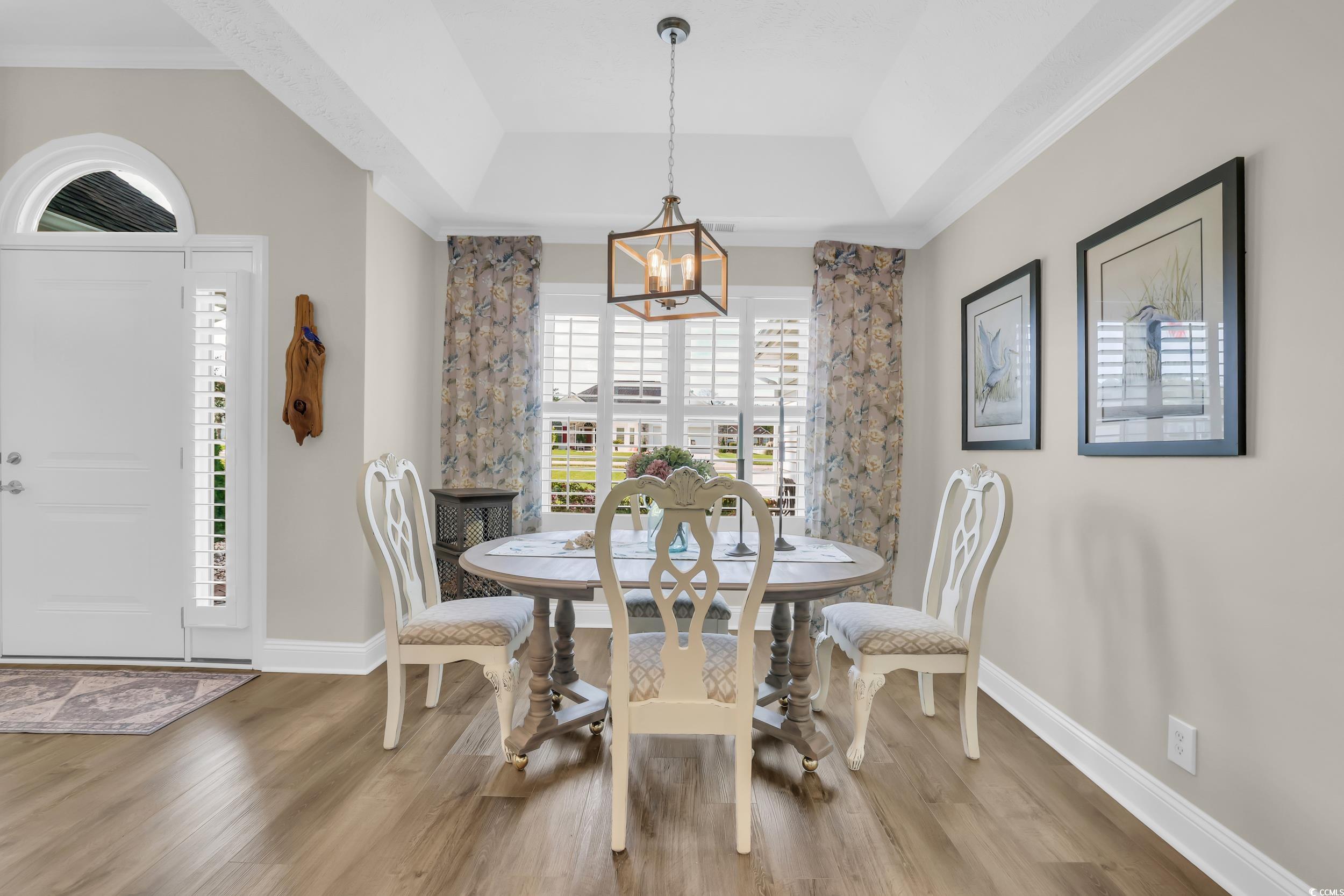 442 Deer Watch Circle Longs, SC 29568 - Photo 9 of 40 Dining space with wood finished floors, a chandelier, ornamental molding, and a tray ceiling